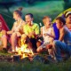 Alaska youth camp grants: group of happy children roasting marshmallows over fire