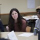 detention facility high school and college: dark-haired white woman sitting at table with group discussing something