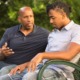 juvenile/youth diversion report: older bald black man talks to young man on park bench