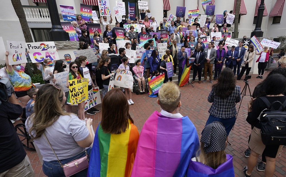 Florida Don't Say Gay bill passes: group of people with rainbow flags and other signs protesting