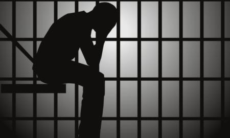 Juvenile detention rough in La. illustration of persn's silhouette sitting with head in hands in jail cell