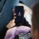 social media use, tiktok: young person laying down opening TikTok on phone