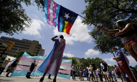 Texas judge blocks investigations of trans youth parents: protesters with flags on a partly cloudy day