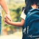 school safety grants: parent holding hand of child going to school