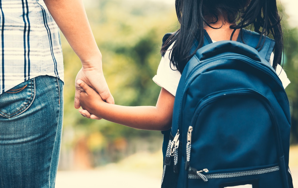 school safety grants: parent holding hand of child going to school