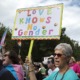transgender youth medical treatments: marchers protesting for trans rights with sign that reads "love knows no gender"