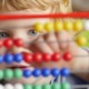 San Diego early childhood grants: young caucasian boy using colorful abacus