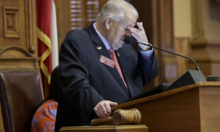 Georgia lawmakers hands transgender decision to sports group: frustrated older white man at podium rubbing forehead