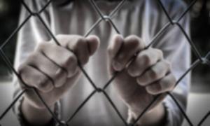 S.C. Juvenile Justice System lawsuit: Two hands intertwined with chain link fence close-up