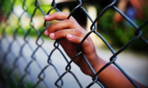 juvenile youth defense improvement grants: young person's hand on chain-link fence