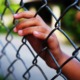 juvenile youth defense improvement grants: young person's hand on chain-link fence