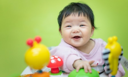 early childhood health grants: happy baby of Asian descent playing