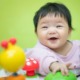 early childhood health grants: happy baby of Asian descent playing