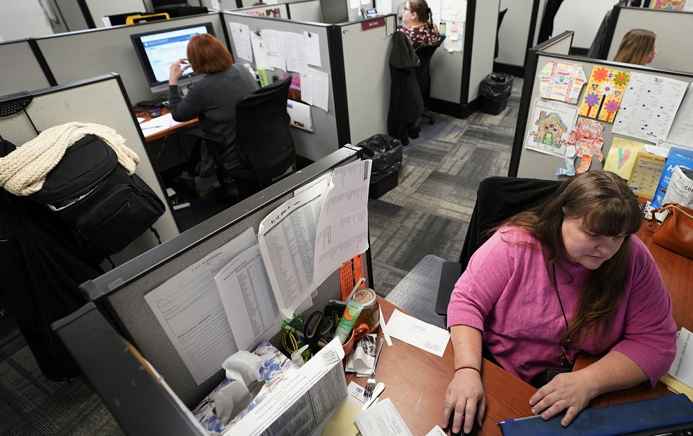 child neglect screening algorithm raises concerns: view of workers in cubicles taking calls