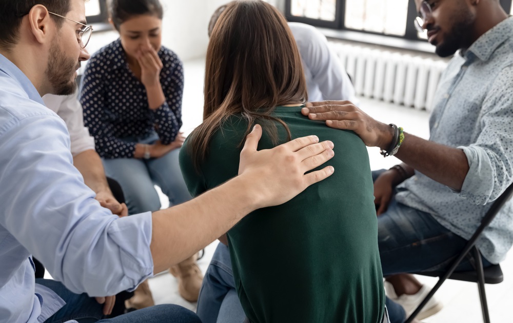 child sexual abuse survivor support grants: young woman being consoled by support group sitting in circle