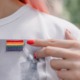 justice-involved LGBTQ youth support center grant: woman with red nail polish pointing at rainbow flag on her shirt