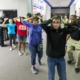 School shootings: Line of several teens with hands up behind heads stand in side building hallway