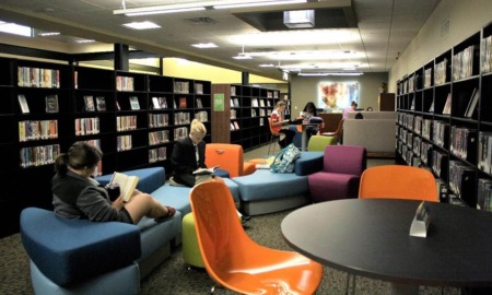 Texas rural library grants: view of updated library with colorful chairs and people reading