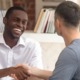 youth-led juvenile justice project grants: young black man in white shirt shaking hands with young white man in office setting