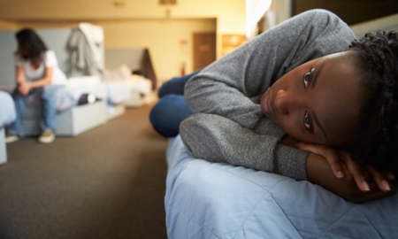 homeless youth transitional living program grants: young black woman lying on bed in shelter