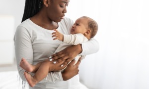 HIV/AIDS, health care; maternity: young black mother holding crying baby