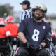 Wheelchair football: Several player in navt team shirt No. 8 and white helmet sits in a wheechair