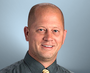 Climate change education: a bald man wearing a dark gray shirt
