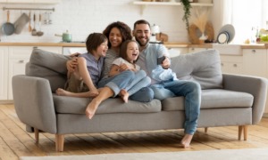 children and youth grants, family economic mobility: happy family laughing on couch