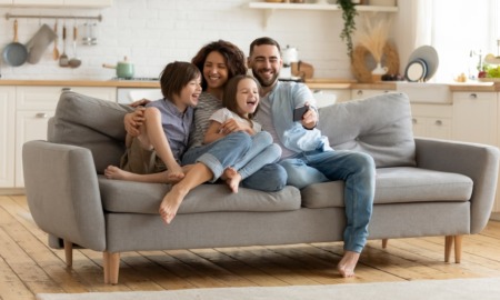 family economic mobility: happy family laughing on couch