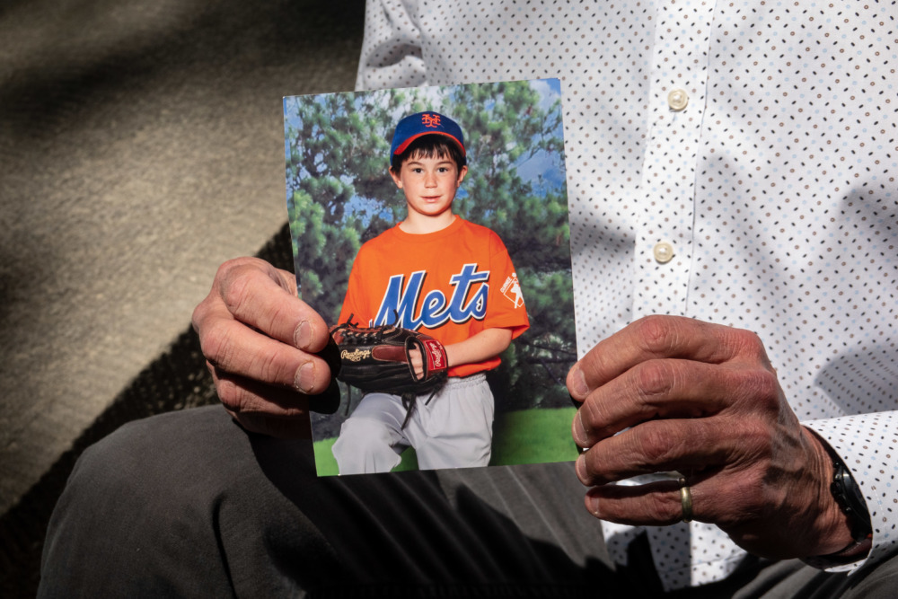 ghost gun rule: hands holding a picture of child in baseball uniform