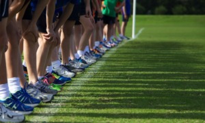 youth running grants: shoes and legs of youths lined up at beginning of race