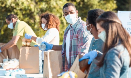 South Carolina poverty alleviation grants: workers in medical masks packing bags of food at food drive
