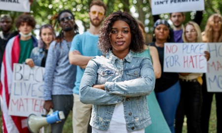 Southeast grassroots social change grants: black woman with arms folded leading a protest with followers standing behind her