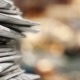 Nebraska school newspaper closed after LGBTQ issue: pile of newspapers with blurry background