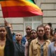 Trauma and suicide risk among LGBTQ youth: group of stoic youth standing with one holding a rainbow flag
