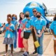 aviation education grants: group of girls in bright blue shirts standing in front of plane on tarmac