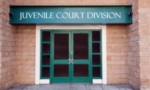 juvenile courtroom division entrance with sign and white-framed green double doors in red brick building