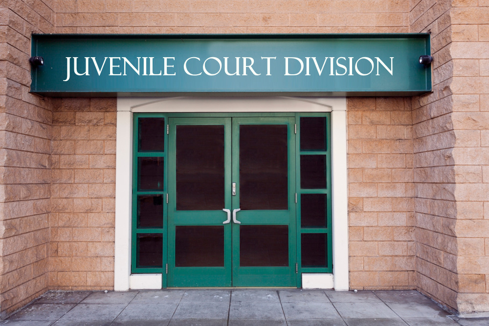 juvenile courtroom division entrance with sign and white-framed green double doors in red brick building