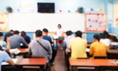 PTA program support: blurred image of parents sitting in classroom talking to teacher