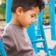 immigrant children and family inclusion advancement research; young ethnic child sitting on playground