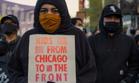 Chicago area youth social change project grants: group of youths with facemasks on holding sign