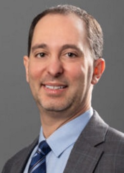 gratitude strengthens nonprofits: headshot of a man with lght brown hair wearing grey suit, blue shrt abs striped blue tie smiling into the camera