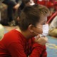 social emotional learning teaching: children on the floor with facemasks on listening to educator