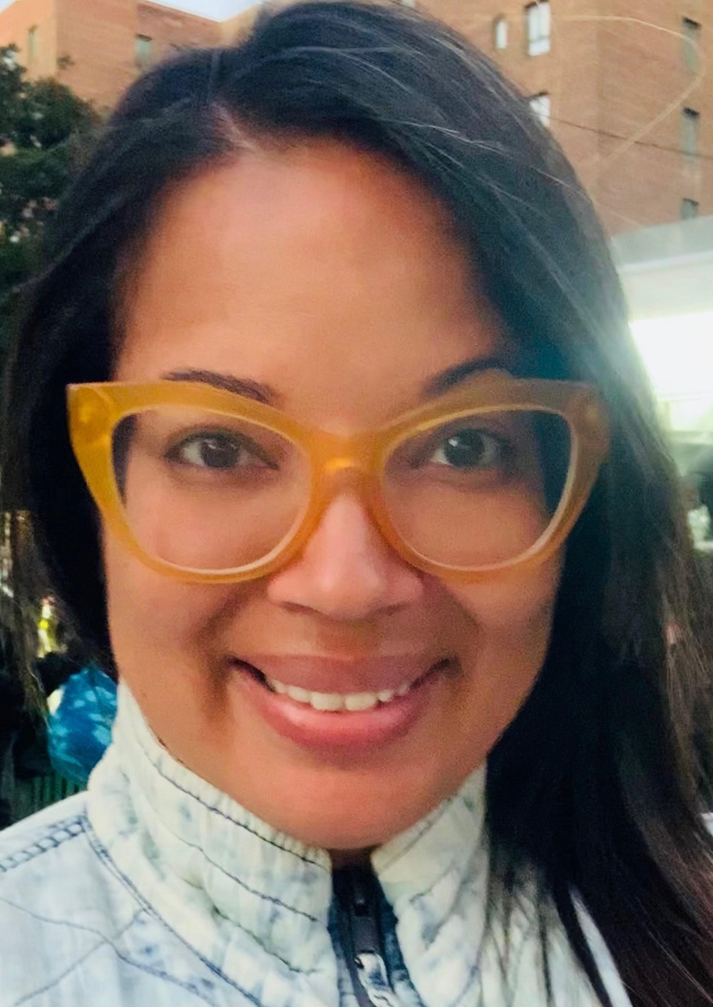 children separated from families due to parental substance use: smiling woman with brightly colored glasses in public setting