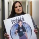 Uvalde mom sues police and gunmaker: Latina woman with long hair holding picture of girl in softball uniform posing