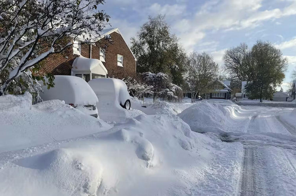 School Snow Days: Red brick 2-story house, tall trees and cars buried in snow amidst huge snow drifts