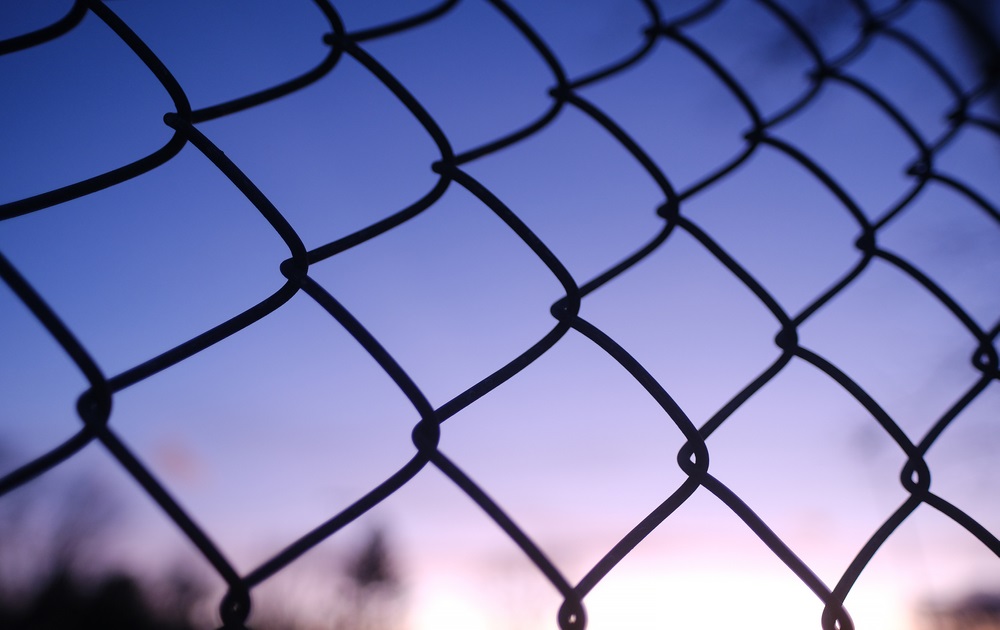 institutionalized children run: chain link fence with sunset