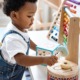 early child care and early education: young black boy in overalls playing with different colorful toys