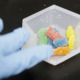 Medical marijuana overdoses: Closeup of gloved hand touching 5 brightly colored gummy bear candies
