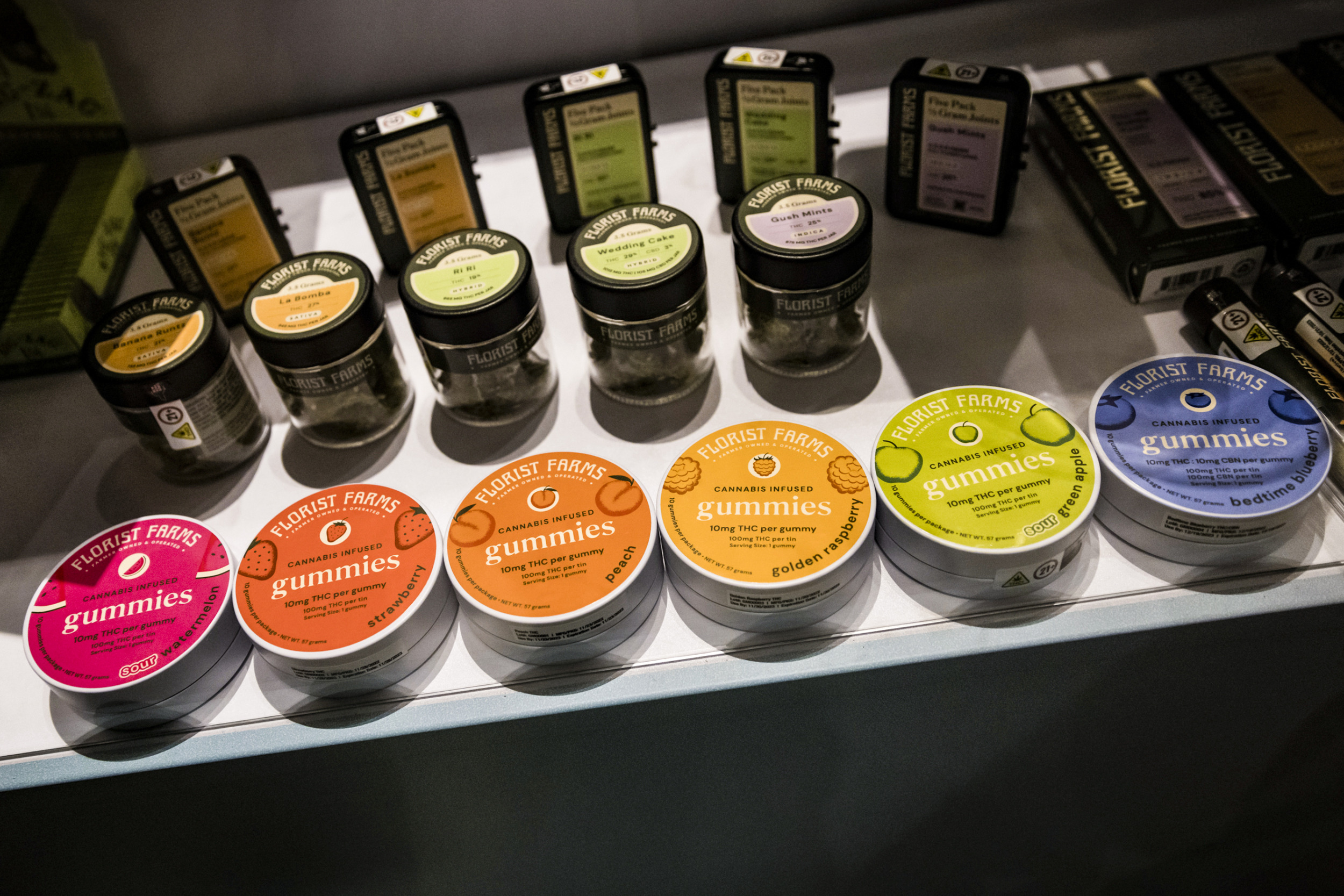 Marijuana packaging: Several colorful tins, jars and bozes lined up on a countertop